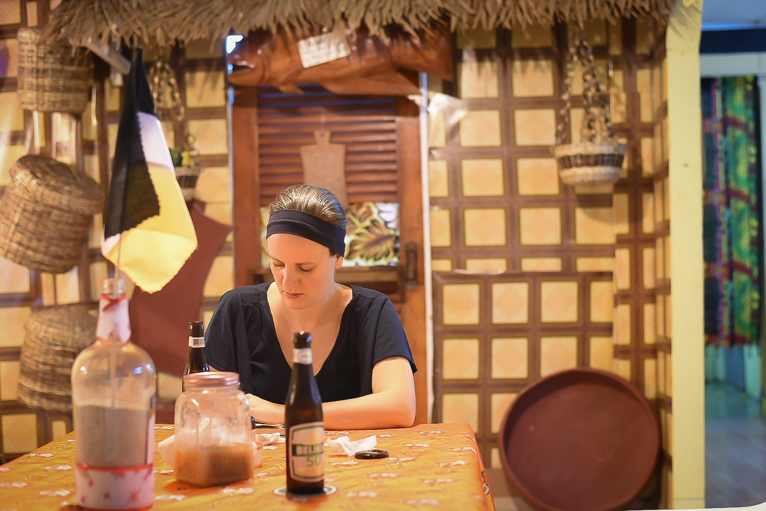 Woman sitting at a dining table in a Garifuna restaurant in Belize writing in a journal