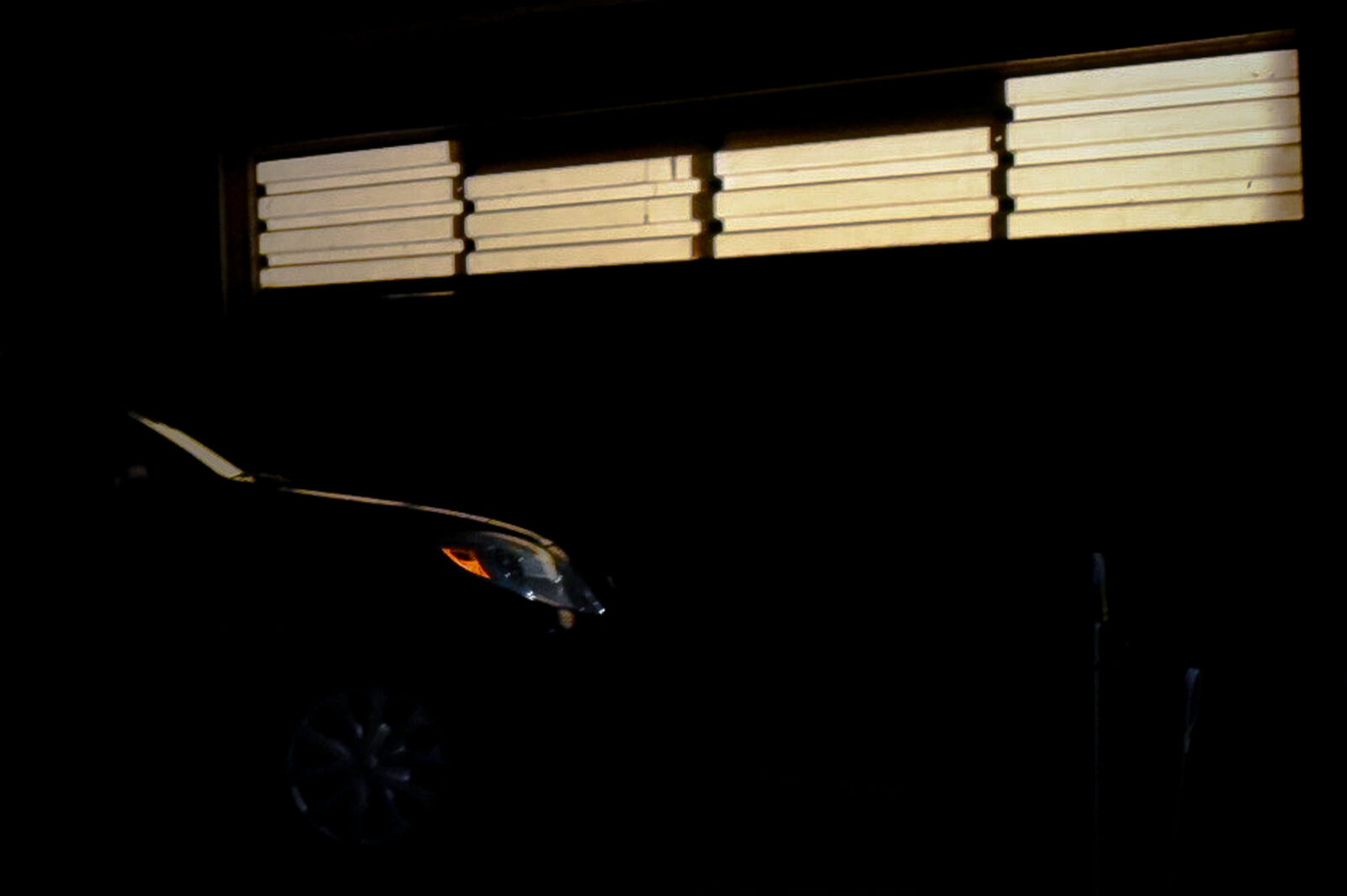 a car parked in front of garage door at night